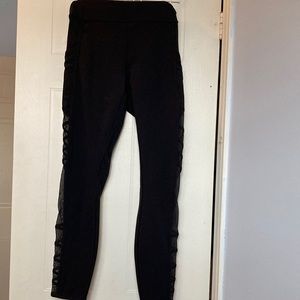 Lululemon black leggings with mesh pockets and side panels.